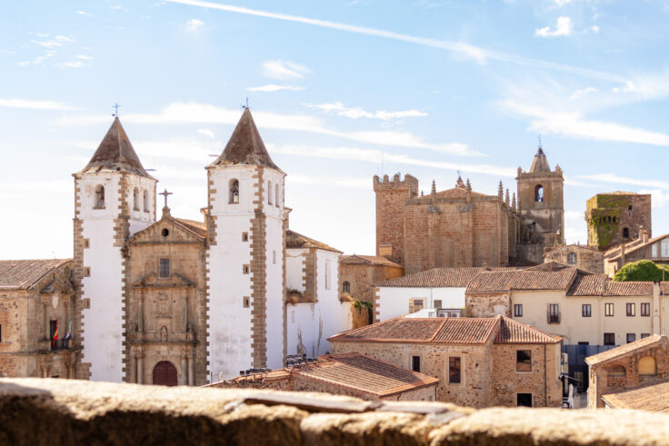 view of the white spires of san fransisco javier church from the cathedral caceres spain