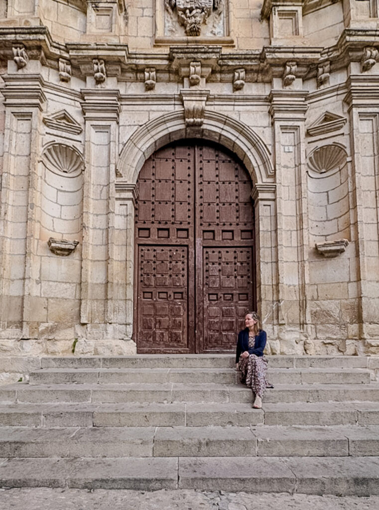 the author sitting on steps in plaza de Merced Cuenca spain