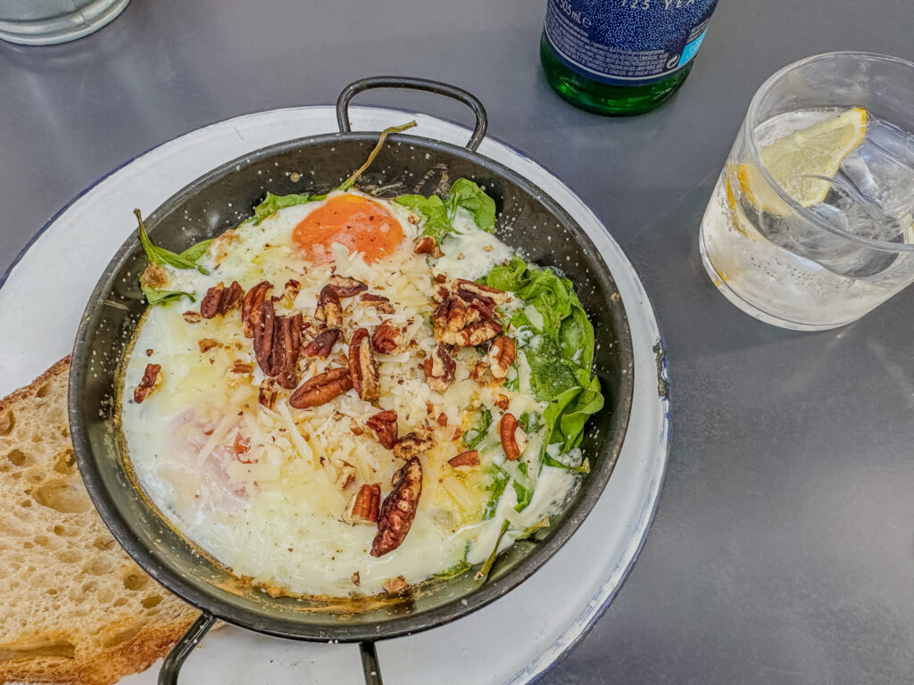 creamy baked egg dish with pecans on top at Plenti restaurant madrid