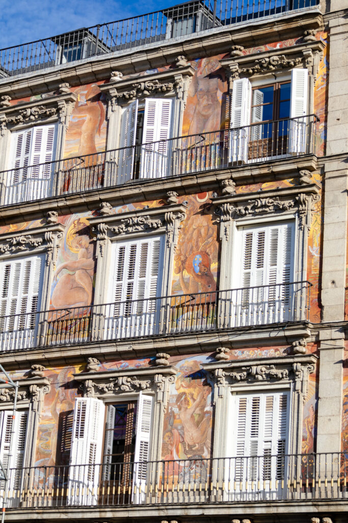 colorful frescos on the bakery building around white shuttered windows plaza mayor madrid