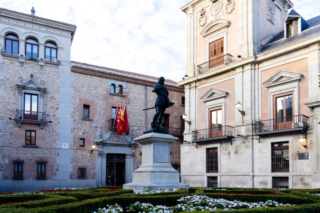 statue and flowers in plaza de la villa madrid 