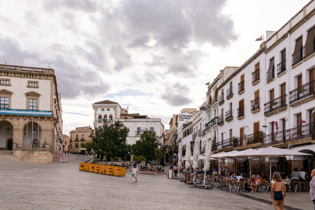 people sitting at tables in plaza mayor in caceres spain