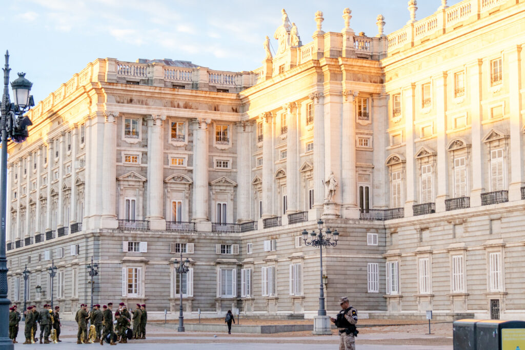 group of military band people holding their instruments in front of the royal palace madrid