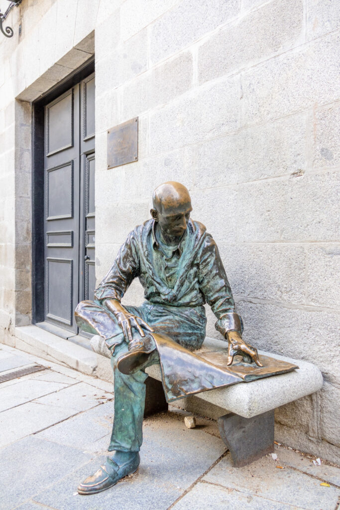 statue of man reading the newspaper in plaza de la Baja madrid