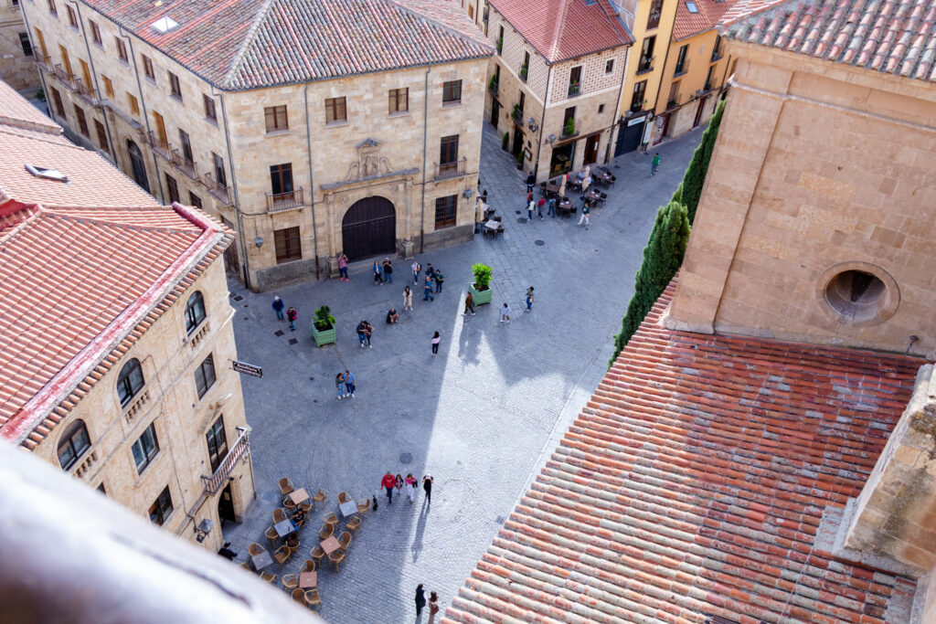 view of plaza below with people and a cafe from scala coeli salamanca spain