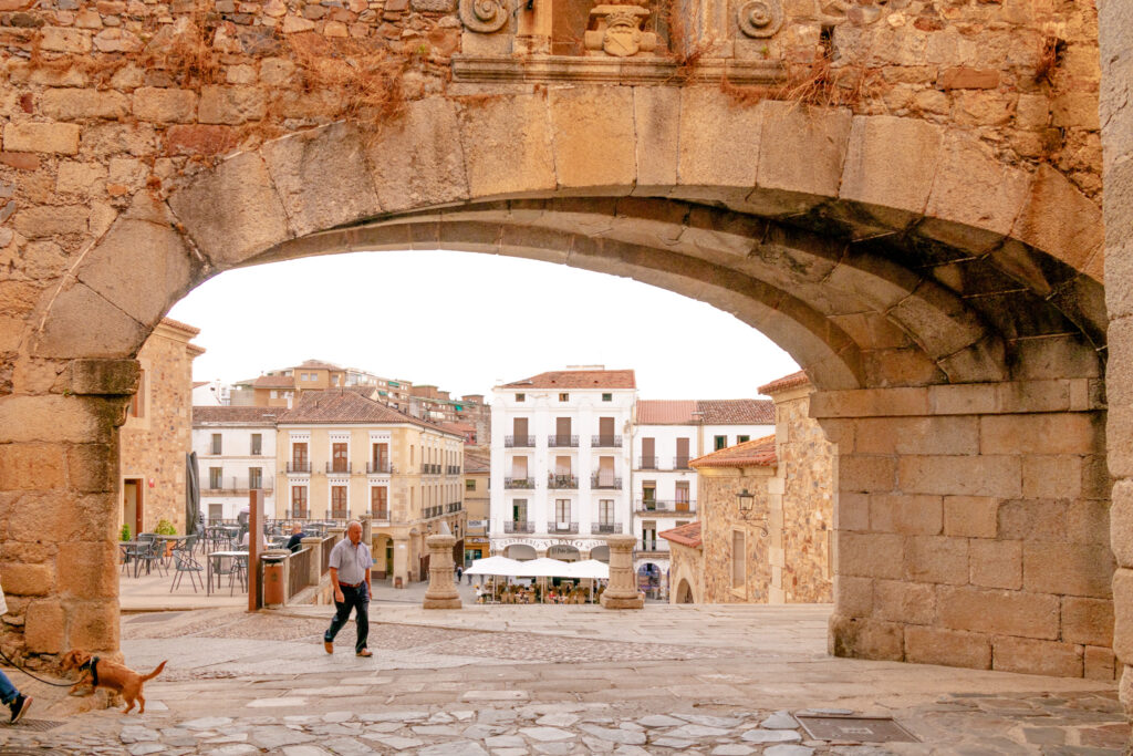 view of the plaza mayor through the star arch caceres spain