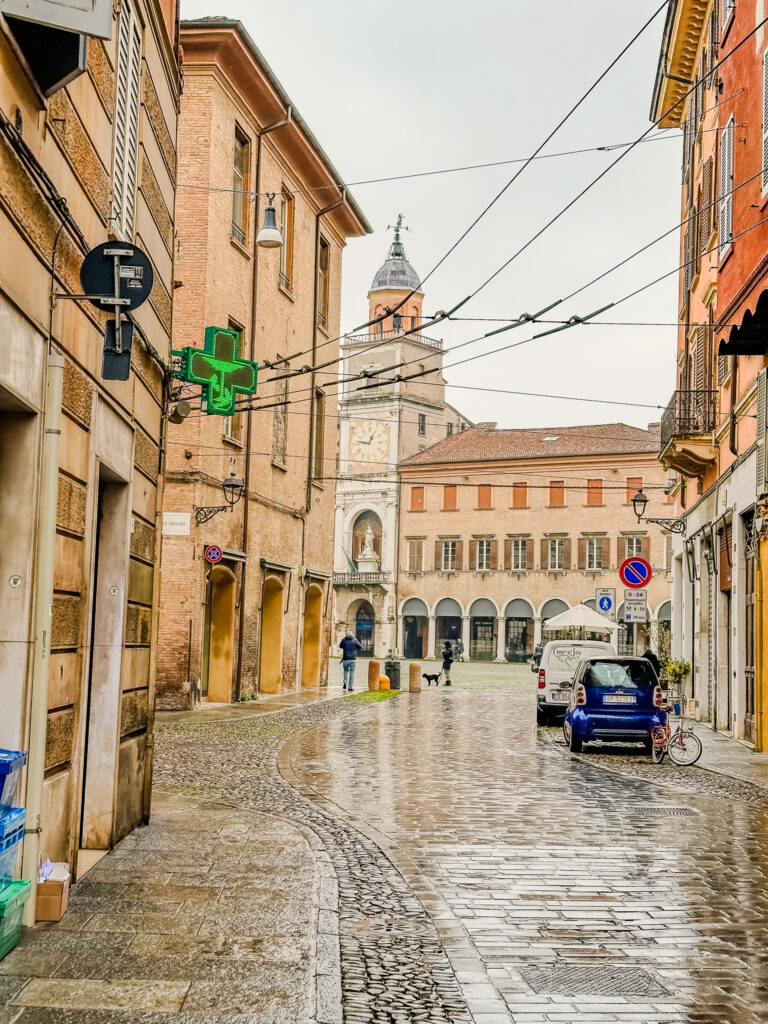 view of piazza grande though buildings in modena italy