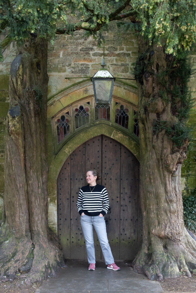 stow-cotswolds-st-edwards-door-maren ✈️ Hey There Travel author in front of the hobbit door