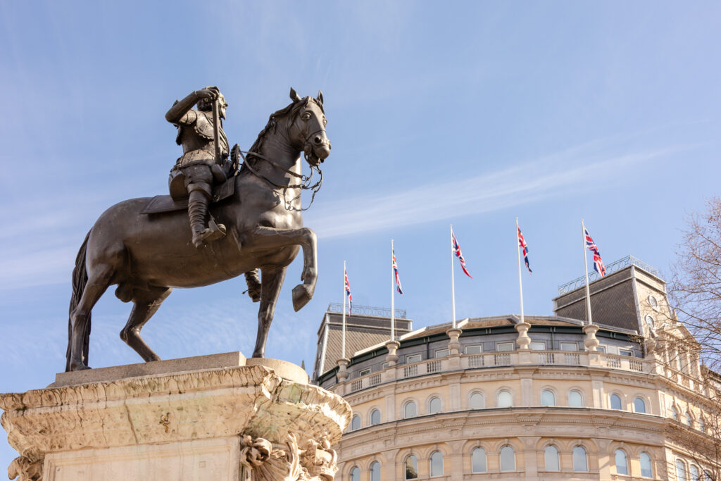 trafalgar-square-statue-london ✈️ Hey There Travel Trafalgar Square statue and British flags flying over a building