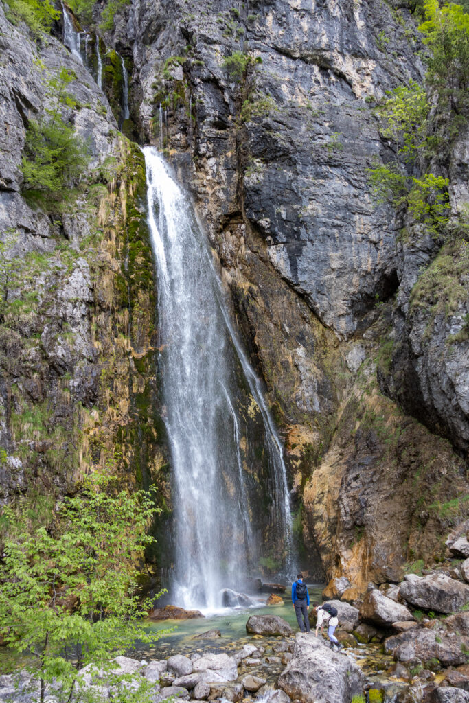 people hiking at the bottom of Grunas waterfall